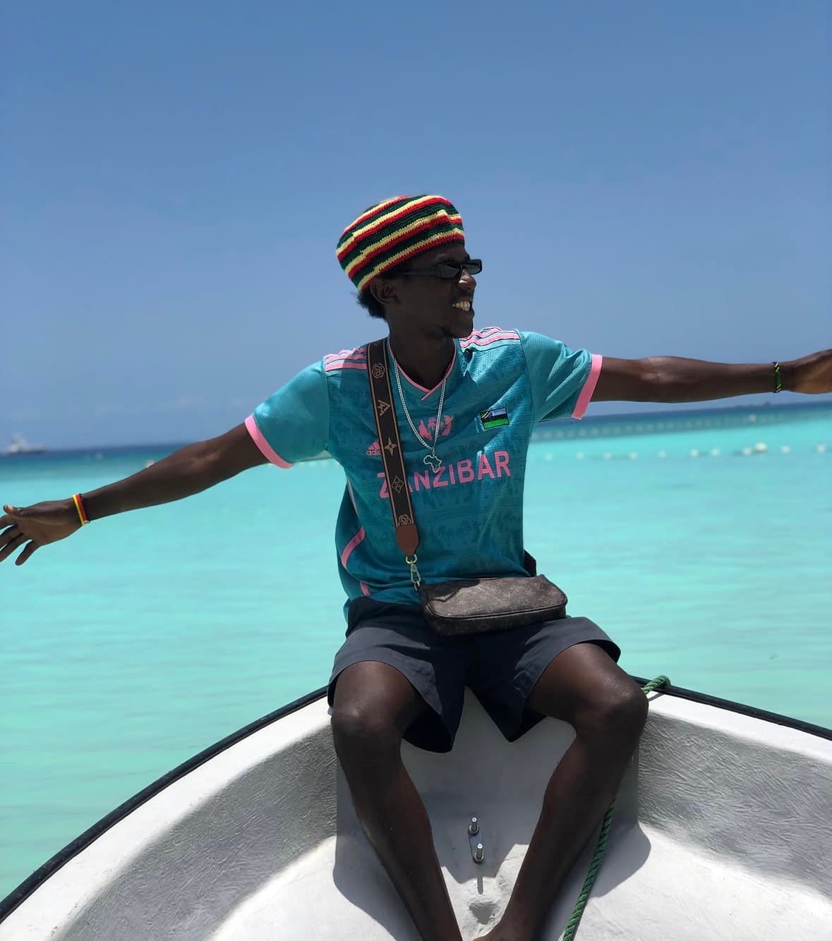 Rama in a Zanzibar jersey on a boat over turquoise water